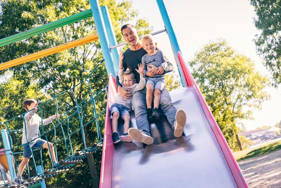 Vater und Söhne rutschen von der Rutsche | Ferienpark Weerterbergen